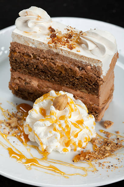 Piece of cake arranged whit whipped cream and syrup in portion on the plate