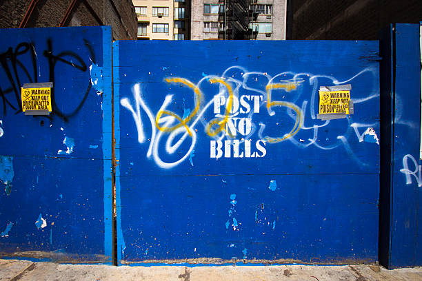 Urban Wall Urban wall at construction site with " Post No Bills " stencil and poison warning plywood stock pictures, royalty-free photos & images