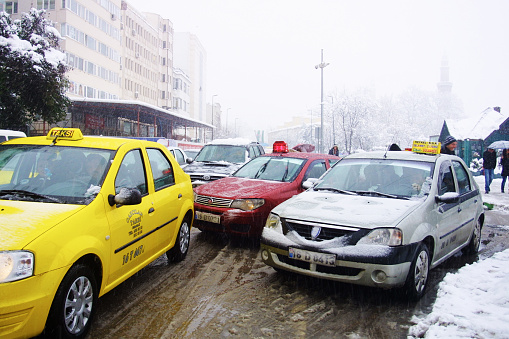 Bursa, Turkey - March 9, 2011: Traffic made by taxi and 'dolmus' cars in snowy winter day in Bursa. In Turkey dolmus (pronounced dolmoosh) are share taxis that run set routes within cities