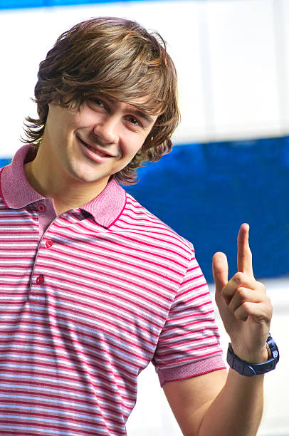 istock Closeup of smiling young man pointing up 471366087