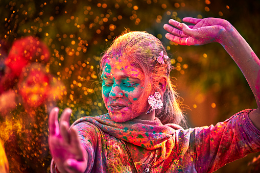 Retrato de mujer India con cara de color bailar durante Holi photo