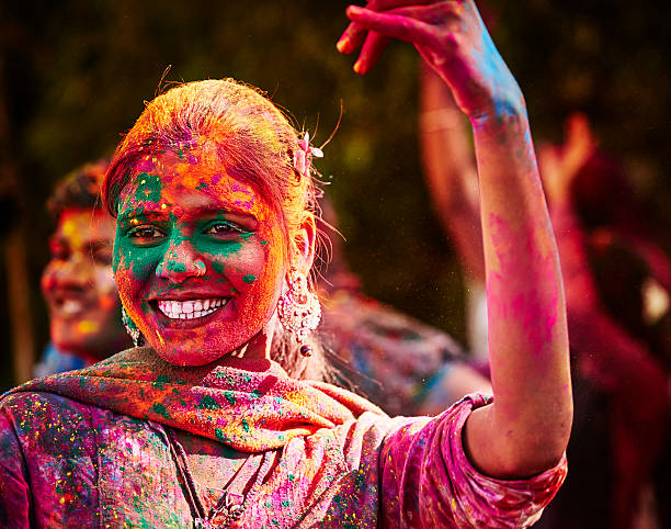 Portrait Of Smiling Indian Girl With Colored Face During Holi stock photo
