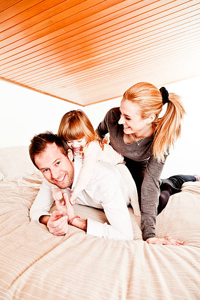 幸せな家族のベッド - three person family flash ストックフォトと画像