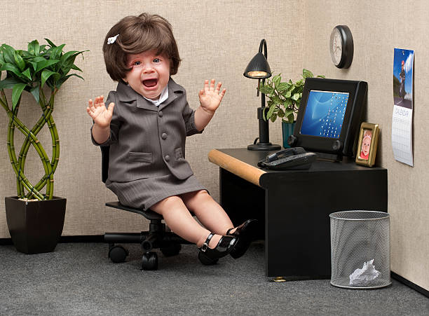 Career Crisis Baby sitting in a business cubicle wearing a business dress with an expression of panic on her face ignorance photos stock pictures, royalty-free photos & images