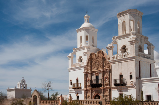 The San Xavier del Bac Mission on the Tohono O'odham Indian Reservation near Tucson, Arizona is captured on a warm spring day.  Nicknamed the 