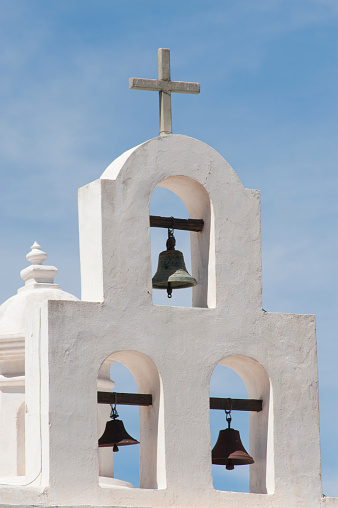 Three bells over the chapel at San Xavier del Bac Mission on the Tohono O'odham Indian Reservation near Tucson, Arizona are photographed on a warm spring day.  Nicknamed the 