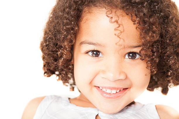 Close-up portrait of a cute little girl smiling over white background. Horizontal Shot.