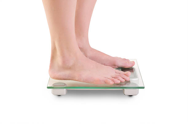 istock Woman legs on scales. 471374715