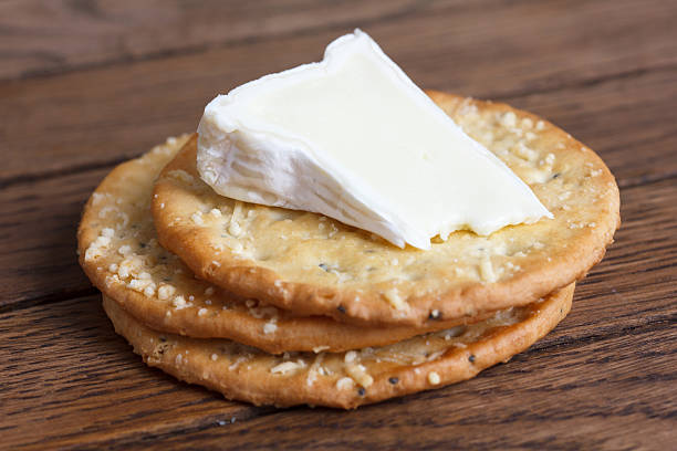 istock Three golden cheese crackers on wood. With cheese. 471375556