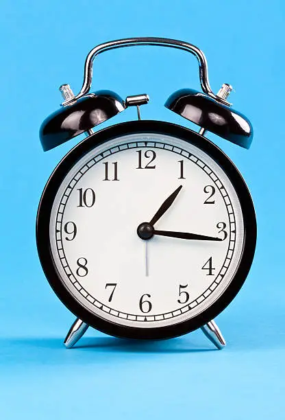 Classic alarm clock on a blue background