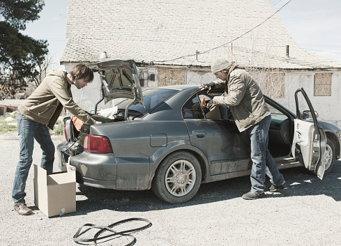 Two homeless men living out of a car.