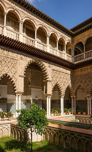 Patio de las Doncellas, Alcazar of Seville, Spain The lower level of the Patio was built for King Peter I in 1364 as a royal residence. The name "Courtyard of the Maidens" (Patio de las Doncellas) refers to the legend that the Moors demanded hundred virgins every year as tribute from Christian kingdoms in Iberia. alcazar seville stock pictures, royalty-free photos & images