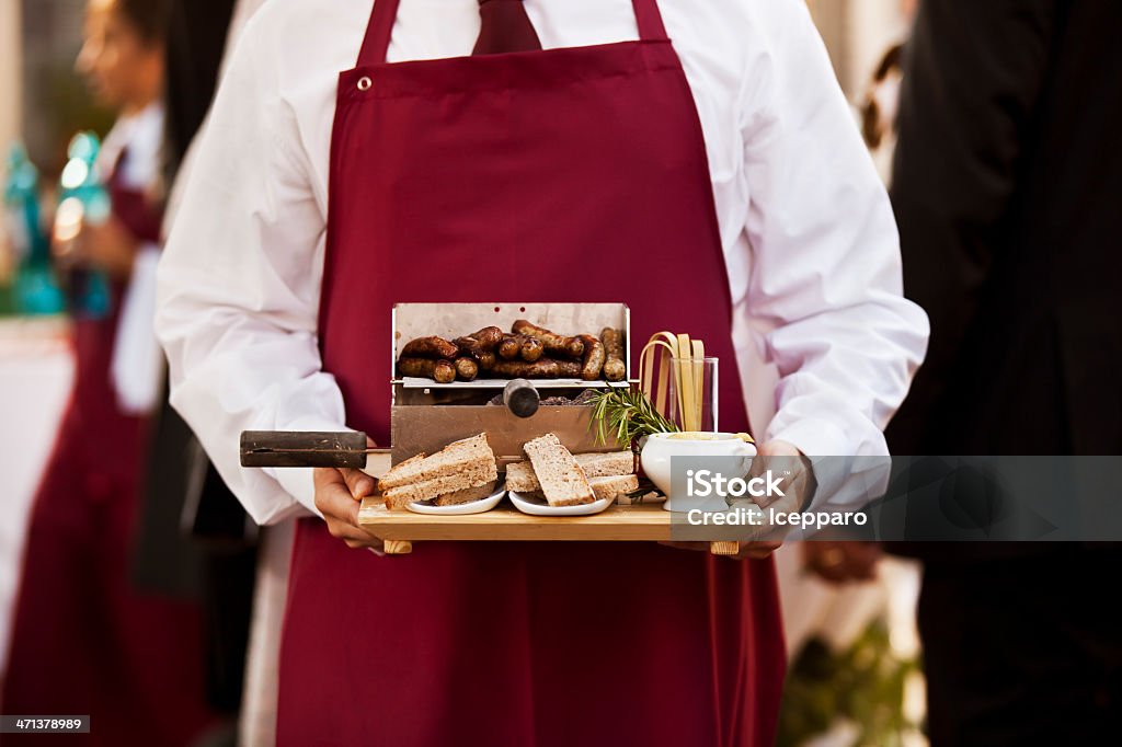 Waitress With Sausage Bread And Sauce Close-up of a waitress serving sausages with bread and sauce Adult Stock Photo