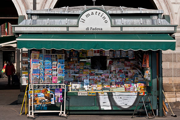 "il mattino" news stand Padua, Italy - January 12, 2012: The newsstand located in the city center in "Prato della Valle" square is open and the owner is waiting for clients. People on background. newspaper seller stock pictures, royalty-free photos & images