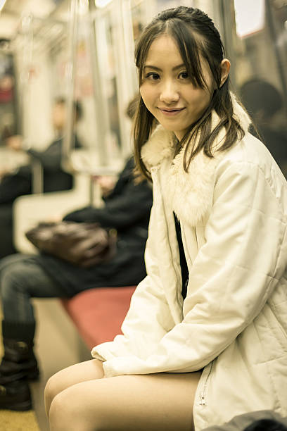 座る女性を東京の地下鉄 - ミニスカート ストックフォトと画像