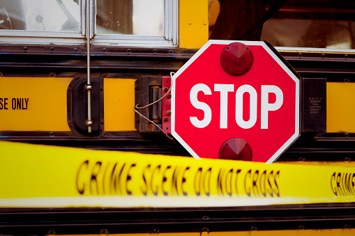 The side of a school bus with cordon tape that reads 
