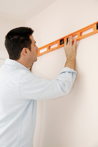 Man Using Level On The Wall Stock Photo - Download Image Now - Adult ...