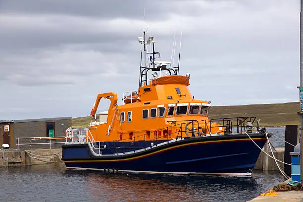 Orange and blue lifeboat moored in the harbour at Lerwick, Scotland.