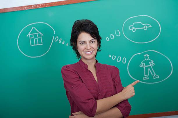 Young woman standing in front of blackboard stock photo