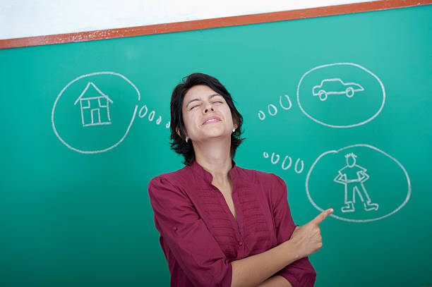 Young woman standing in front of blackboard stock photo
