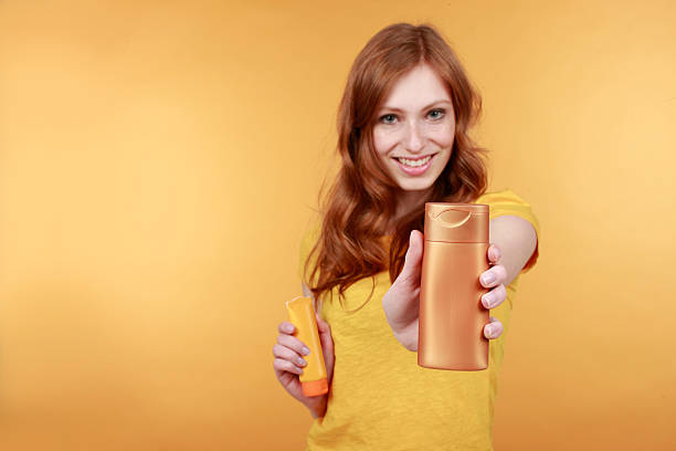 istock Young  red haired woman with sun lotion 471387518