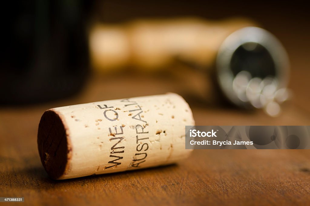 Wine of Australia Cork Horizontal Cork with "Wine of Australia" stamped on it with a corkscrew and wine bottle in the background. Alcohol - Drink Stock Photo
