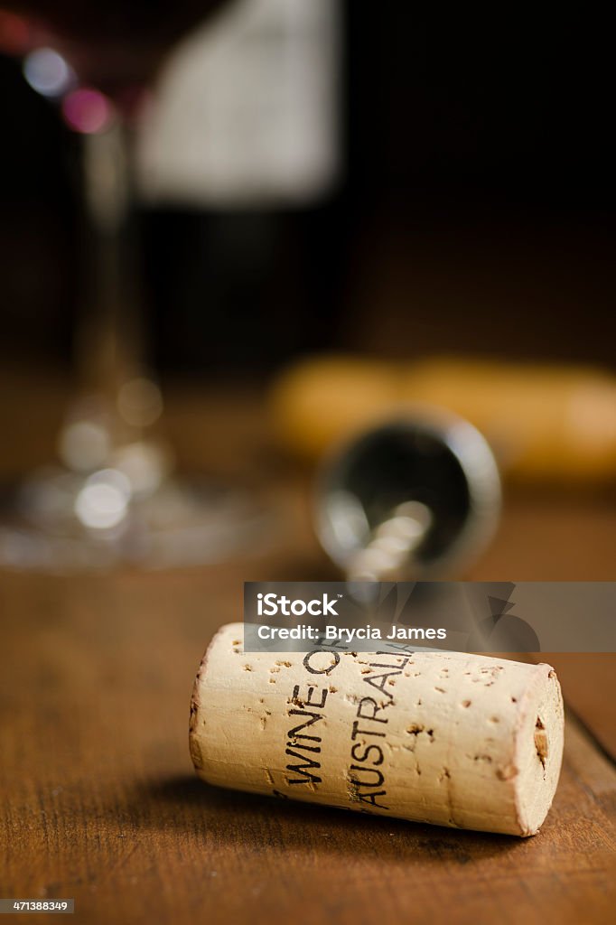 Wine of Australia Cork Vertical A cork with "Wine of Australia" stamped on it with a corkscrew, glass of wine, and wine bottle in the background.  Copy space available in the upper right corner. Alcohol - Drink Stock Photo