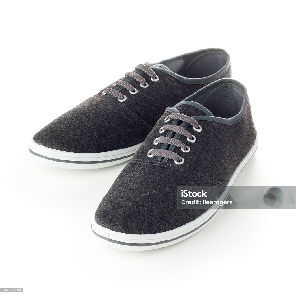 Grey canvas deck shoes isolated on a white background The shoes are grey canvas with white soles and they have grey laces. They are isolated on a white background. White soled shoes are often used on boats so they don't mark the ships deck. Boat Shoe Stock Photo