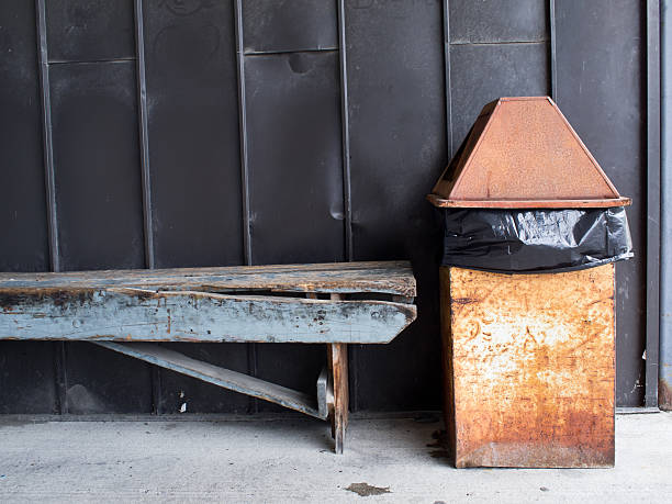 wood bench metal wall garbage can garbage bag cement