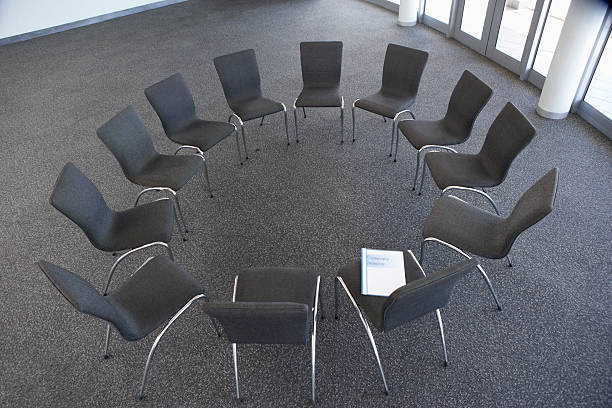 Chairs in a circle with focus on the orange colouredchair concept related lightbox:
