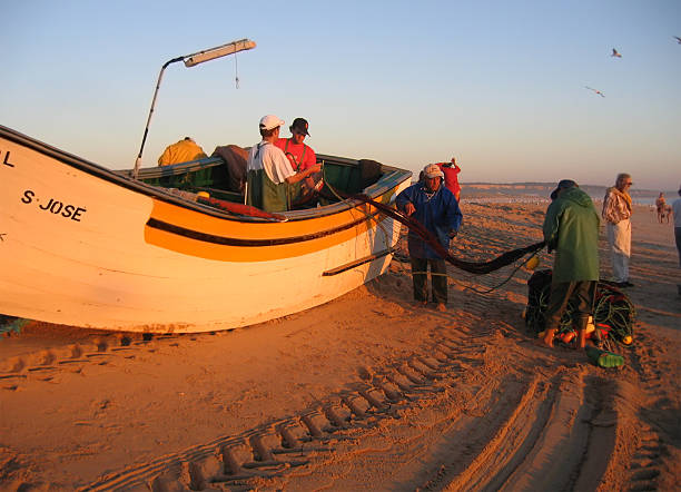 Armacao de Pera, Algarve, Portugal - March 30, 2018:\nColorful fishing boats on the beautiful sandy beach of Armacao de Pera, Silves, Portugal, Algarve, Europe