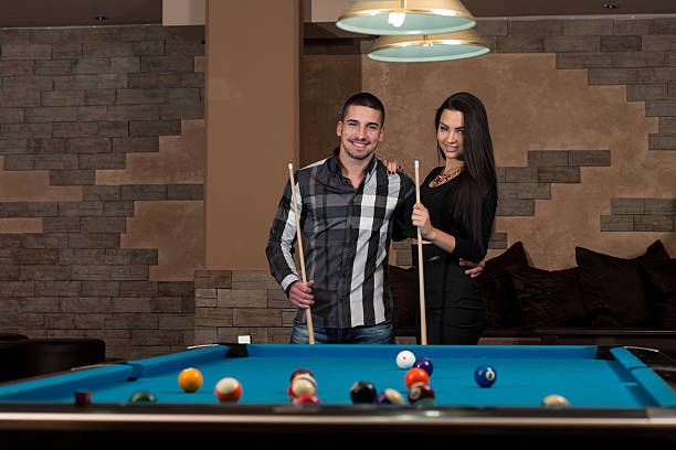 istock Smiling Happy Couple Playing Billiard 471393448