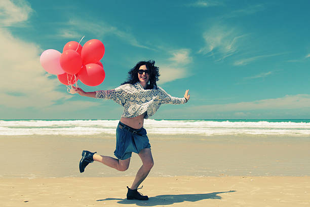 istock beautiful woman holding red balloons 471397564