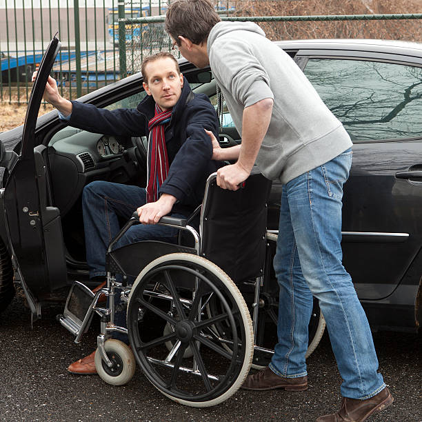 uomo aiutando una persona disabile - disablement foto e immagini stock