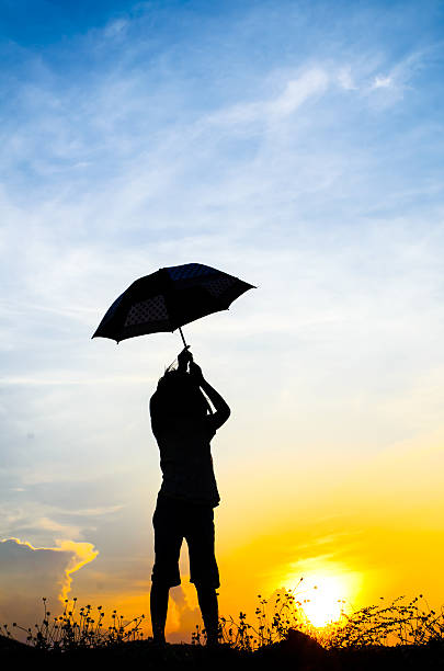 istock Motion blur jumping Umbrella girl with sunset silhouette 471397680