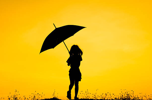 istock Umbrella girl with sunset silhouette 471397686