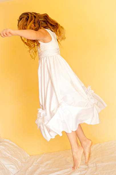 istock Young girl jumping on a bed 471398073