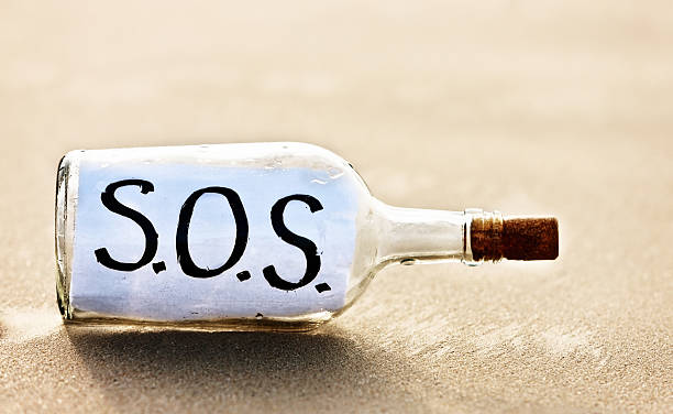 выцветший-бутылка с организацией sos сообщение от stranded изгой - message in a bottle beached bottle desert island стоковые фото и изображения