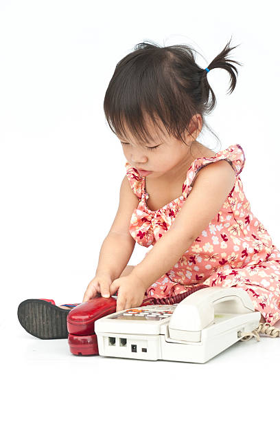 istock Baby dialing old beige phone calling 471400463