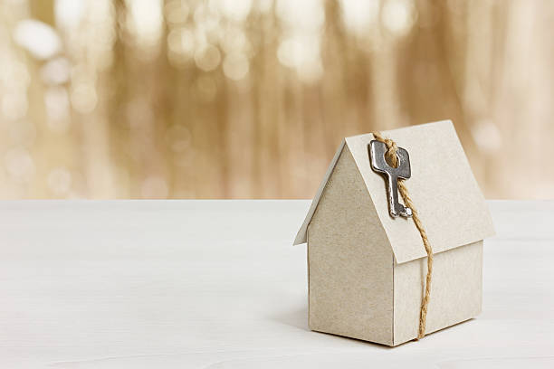 istock cardboard house with key, buying a new home concept 471400652