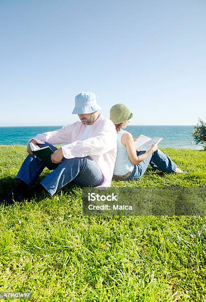 Reading On The Beach Stock Photo - Download Image Now - Book, Couple - Relationship, Sea