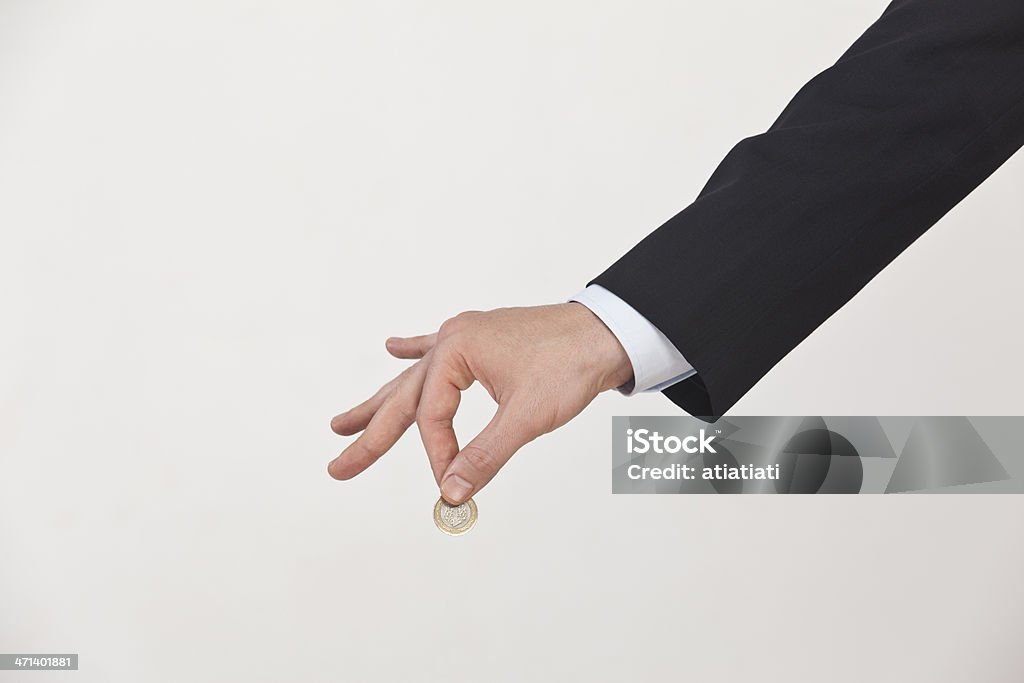 Uomo d'affari tenendo una moneta - Foto stock royalty-free di Moneta