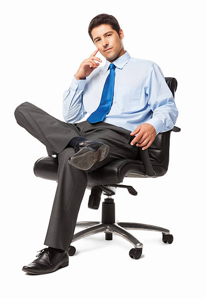 Portrait of a confident businessman sitting in an office chair. Vertical shot. Isolated on white.