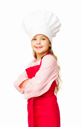 Portrait of a cute little girl dressed up as a chef standing with arms crossed. Vertical shot. Isolated on white.