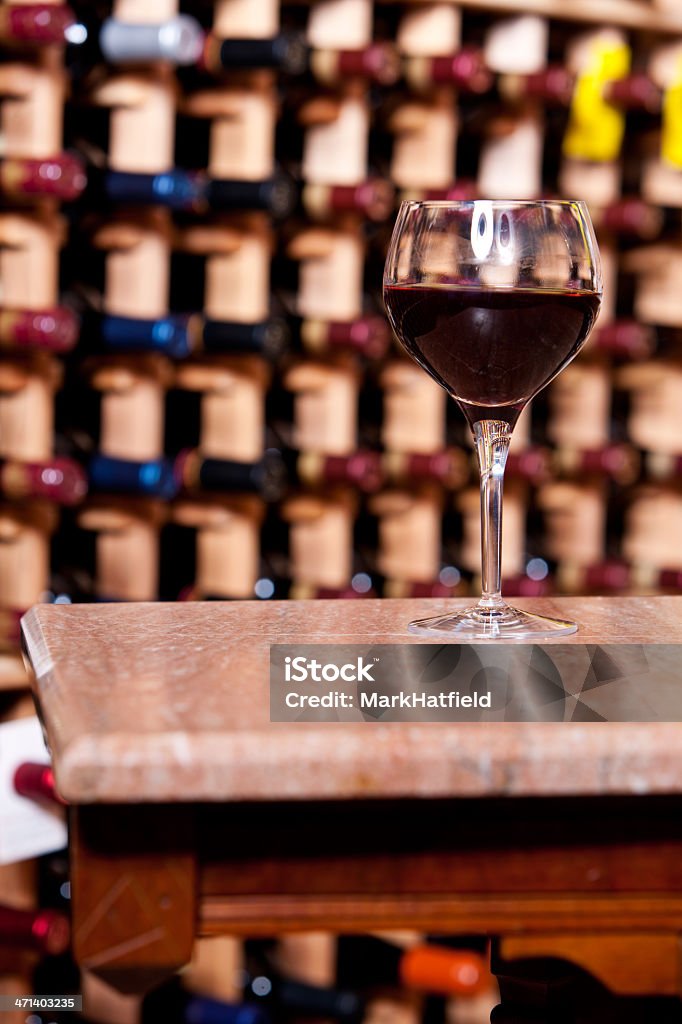 Kieliszek wina na stole w piwnicy - Zbiór zdjęć royalty-free (Alkohol - napój)
