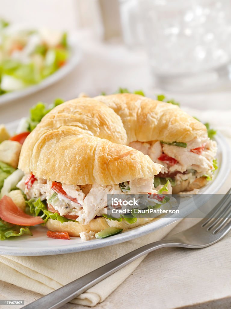 Chicken Salad Sandwich on a Croissant A Creamy Chicken Salad Sandwich with Red Peppers, Cucumber, Lettuce and Tomato on a Croissant and a Side Salad- Photographed on Hasselblad H3D2-39mb Camera American Culture Stock Photo