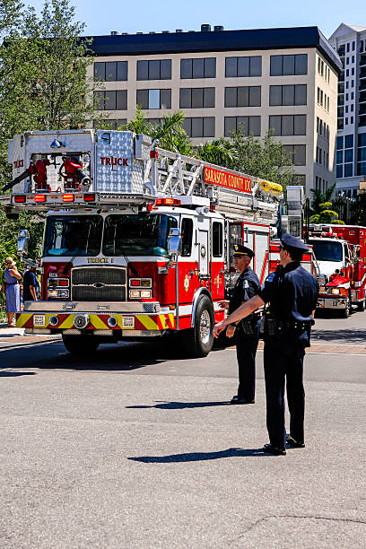 Fire engine in Sarasota Sarasota, FL, USA - May 26, 2014: A fire truck being directed by the Police in downtown Sarasota FL during a large scale exercise in Hurricane Management police and firemen stock pictures, royalty-free photos & images