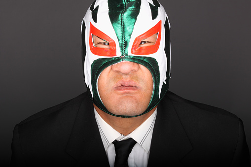 Man wearing a suit and luchador mask.