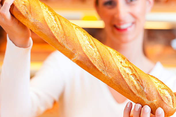istock Female baker in her bakery with baguette 471409759