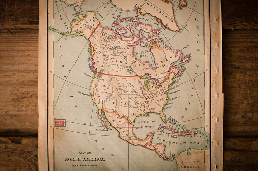 Color image of an old map of North America, from the 1800's, sitting on wood background.